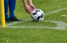 Player Placing a Football Onto the Pitch, Ready to Be Kicked