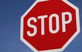 Stoppskylt mot blå bakgrund