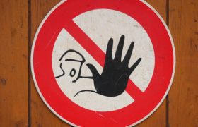 Varningsskylt där en man signalerar stopp