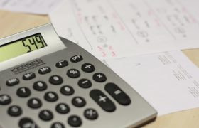 Kalkylator och papper på ett bord