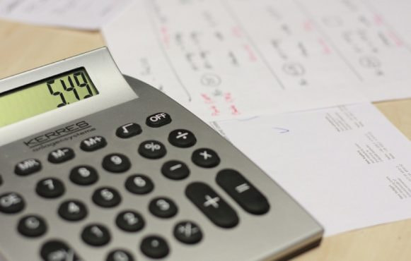 Kalkylator och papper på ett bord