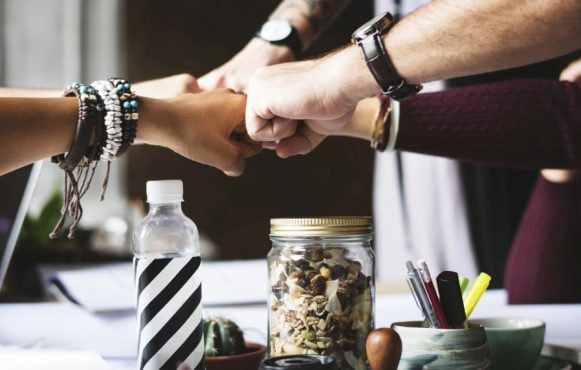 Fyra personer som gör fist bump