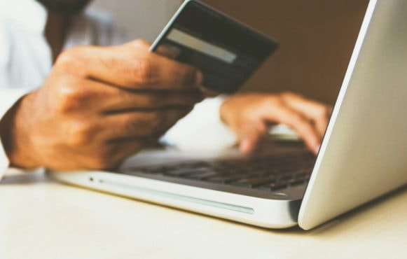 A Person Using a Card to Pay Online