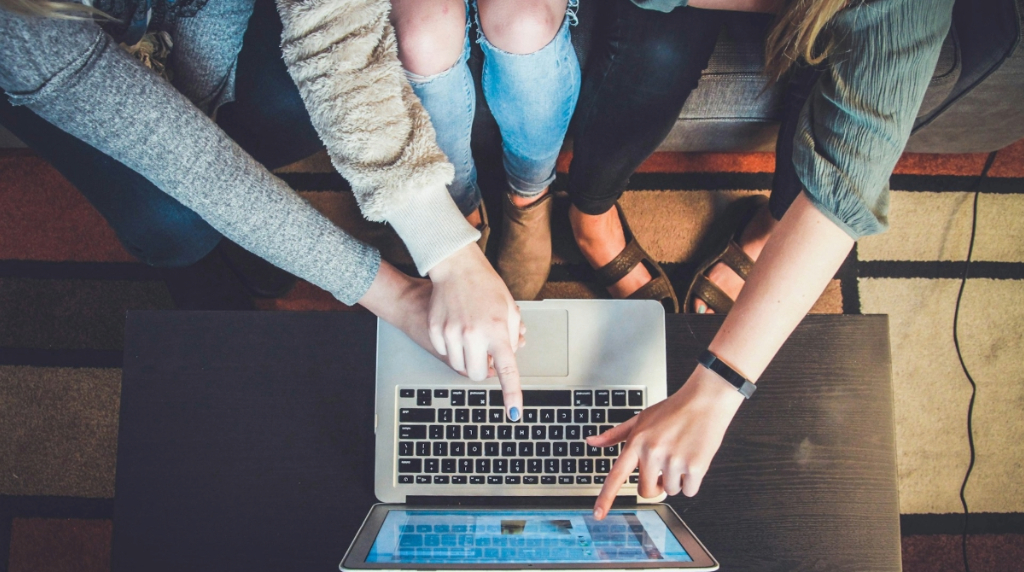 Three People Using a Laptop
