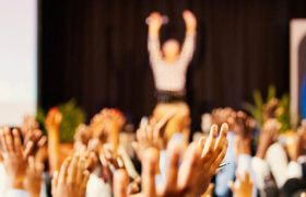 Händer i luften på konferens