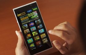 Någon håller i en telefon med en mobil casino app öppen.