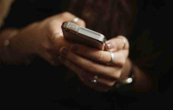 An image showing a person using a mobile phone for gambling