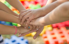Group of People with Their Hands Piled on Each Other