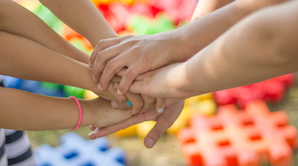 Group of People with Their Hands Piled on Each Other