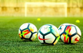 A Row of Footballs on a Pitch
