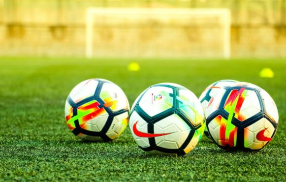 A Row of Footballs on a Pitch