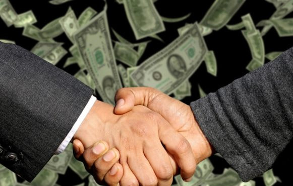 A Handshake and Dollars on the Background