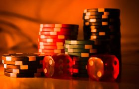 Högar med spelmarker och två röda tärningar med vita prickar