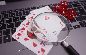 Spelkort, förstoringsglas och tärningar på tangentbord