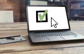 En dator med ett grönt tecken för godkänd