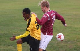 Två fotbollsspelare i kamp om bollen på planen.