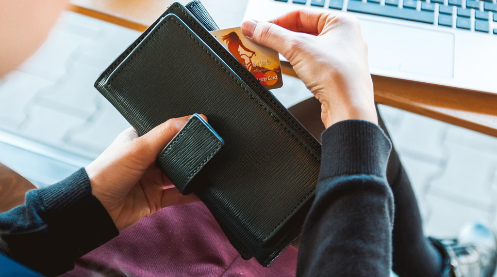 Someone Taking a Card Out to Make an Online Payment