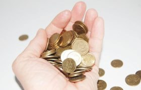 Hand som håller i mynt