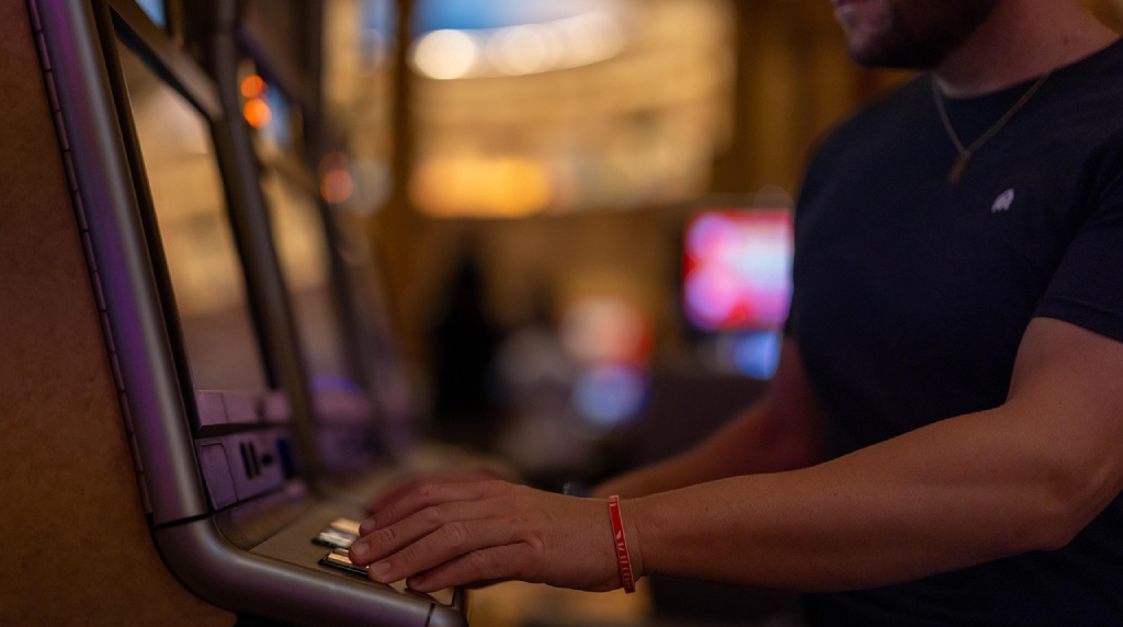 An image showing a person playing slots at the casino