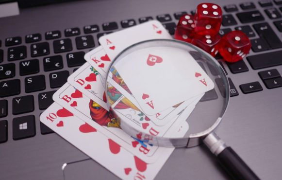 Spelkort och förstoringsglas på tangentbord