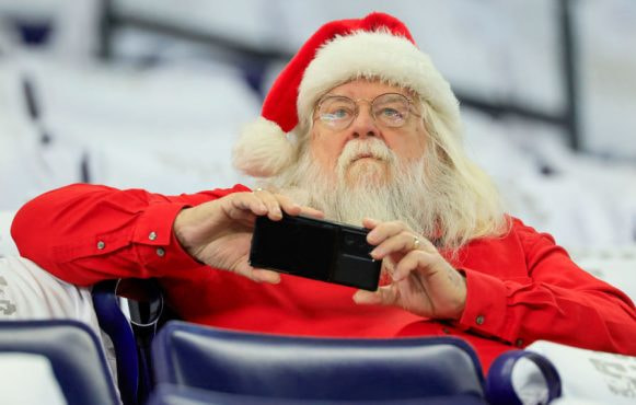 Santa Claus Looking at His Mobile Phone.
