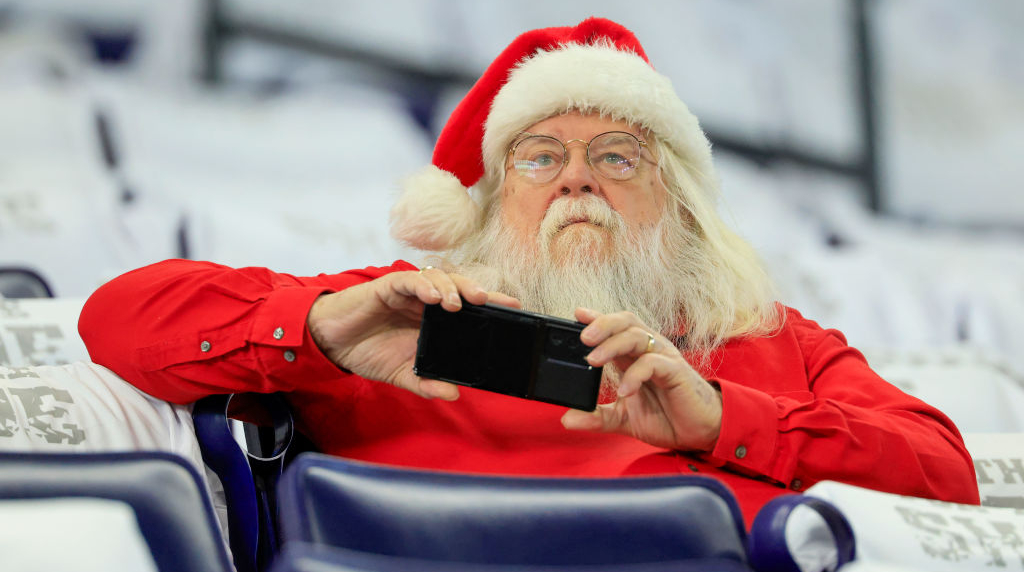 Santa Claus Looking at His Mobile Phone.