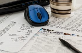 Bilden visar sakttepapper, penna, och en kaffemugg