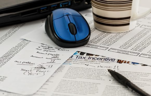 Bilden visar sakttepapper, penna, och en kaffemugg