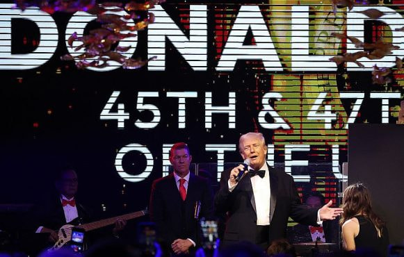 Donald Trump on stage with a microphone in hand.