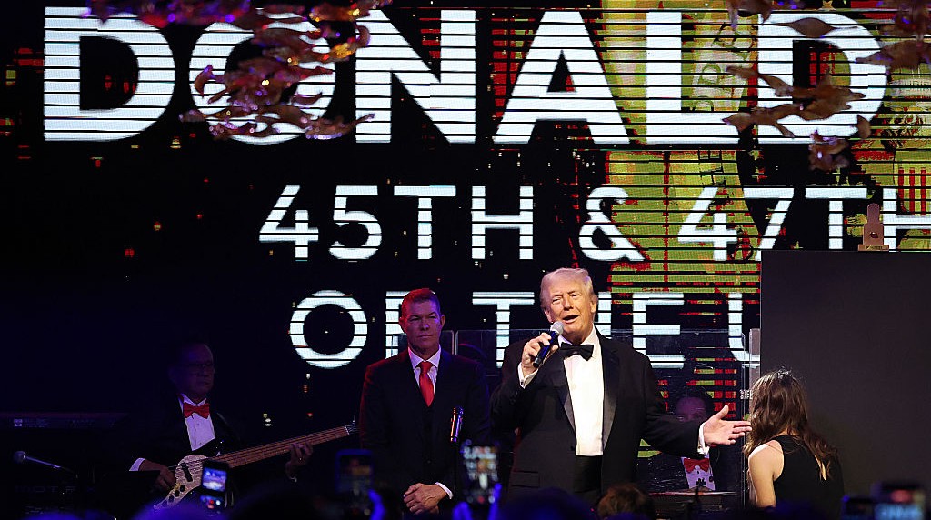 Donald Trump on stage with a microphone in hand.