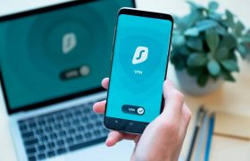 VPN Apps Shown on a Phone, With a Laptop in the Background