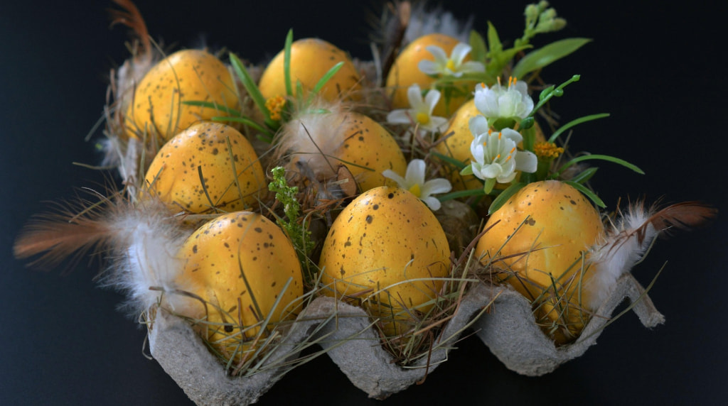 Gula ägg i blommor i äggkartong