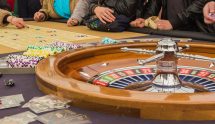 Casinospillere rundt om roulettebord.