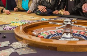Casinospillere rundt om roulettebord.