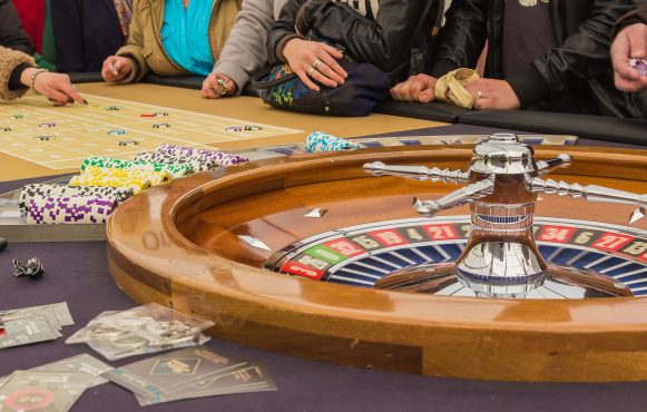 Casinospillere rundt om roulettebord.
