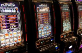 Slot machine illuminate in fila dentro un casinò