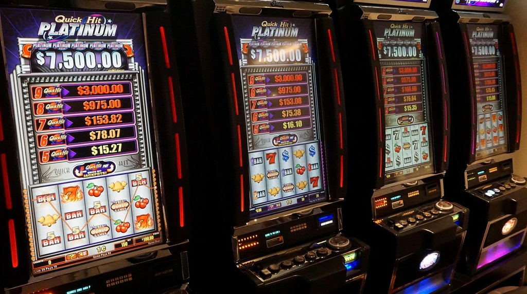 Slot machine illuminate in fila dentro un casinò