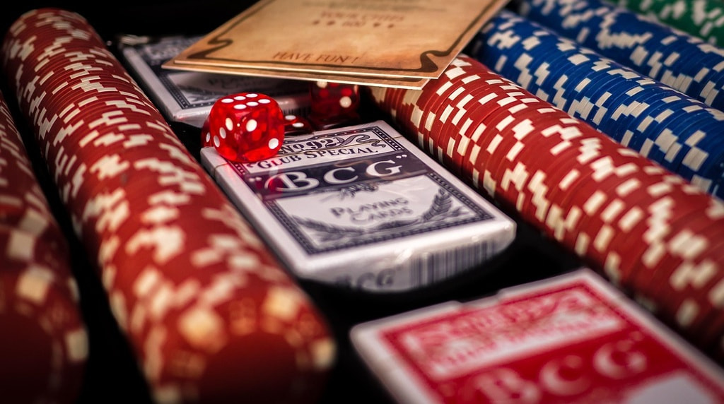 Fiches rosse e blu, carte da gioco e dadi su un tavolo da casinò