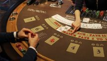 Person i sort sidder ved blackjackbord