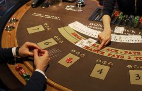Person i sort sidder ved blackjackbord