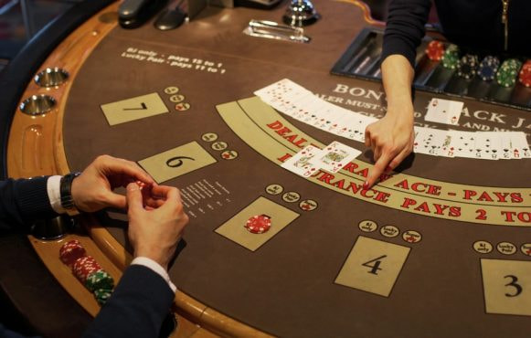 Person i sort sidder ved blackjackbord