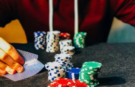 Ung person med pokerchips og kort.