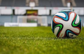 Fodbold ligger på græs i stadium
