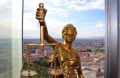 Retfærdighedsstatue foran by Horisont