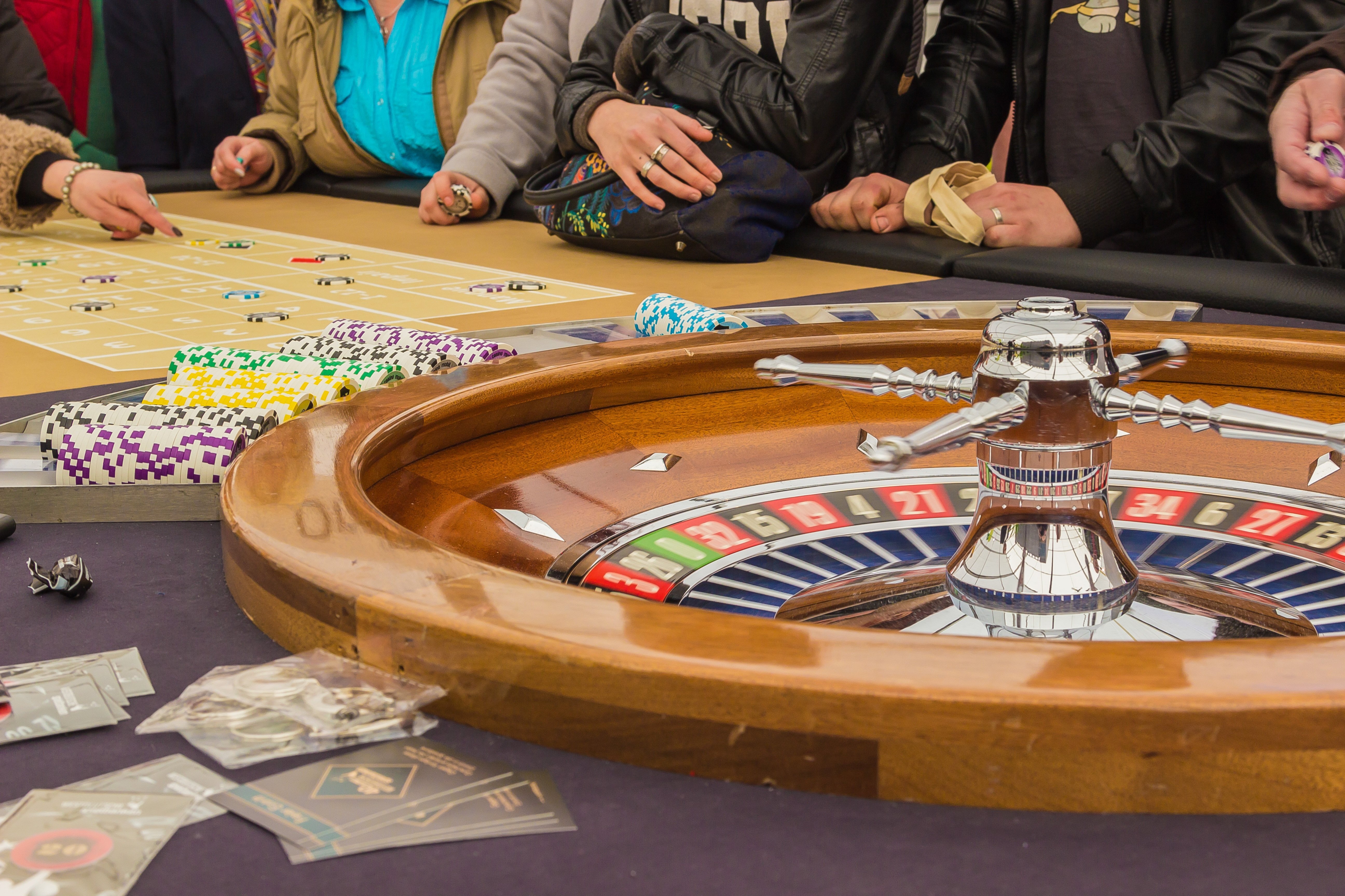 Casinospillere rundt om roulettebord.