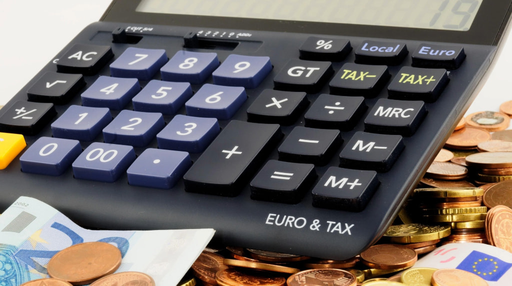 Una calcolatrice con monete e banconote in euro