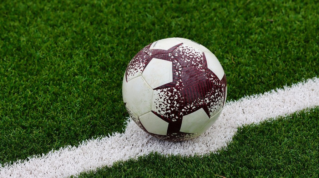 Pallone da calcio consumato, fermo sulla linea bianca