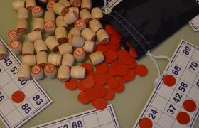 Cartelle bingo, gettoni rossi e numeri legno
