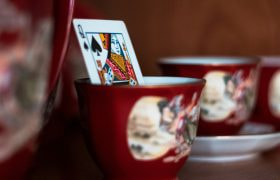 Carta da gioco in tazza rossa decorata su scaffale