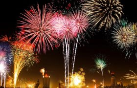 Fuochi d’artificio illuminano il cielo notturno sopra la città.